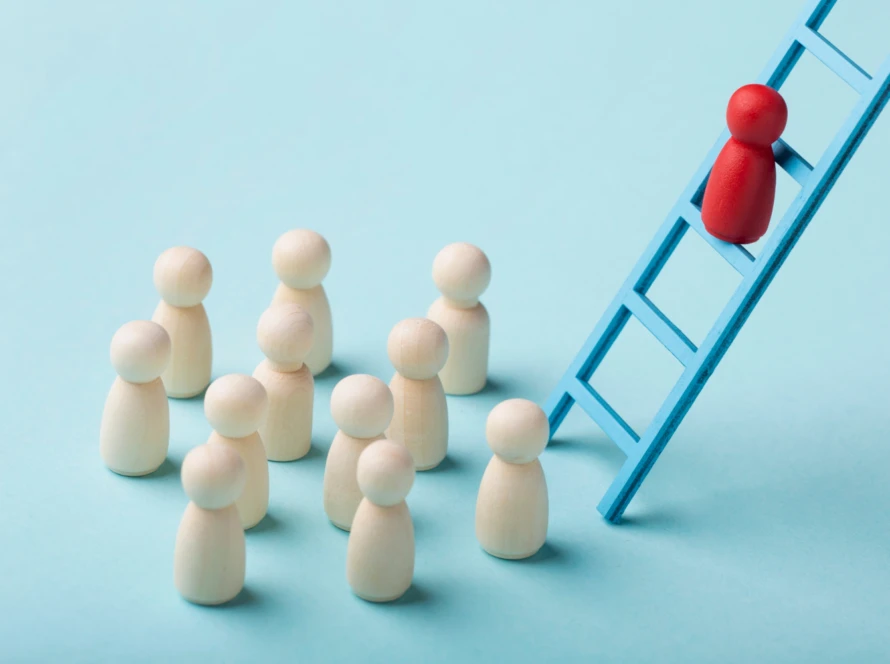Red wooden figure climbs a blue ladder while neutral wooden figures watch from below – visualization of situational leadership that contrasts mentoring with managing